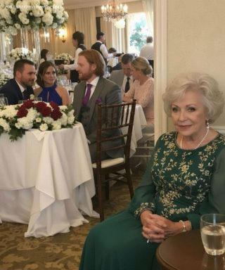 Matkę Pana Młodego po cichu usunięto z listy gości weselnych — posadzono ją przy drzwiach dla służby, jakby nie należała do tego grona, aż do momentu, gdy jakiś mężczyzna zapytał: „Dlaczego ona jest z tyłu sali weselnej swojego syna?”, po czym całe przyjęcie ucichło.